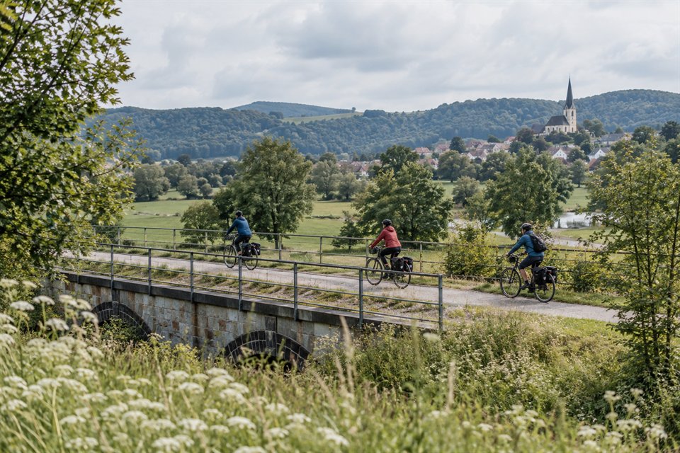 Radfahrende auf einem stillen Weg durch die Landschaft